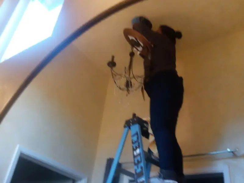 Electrician installing a chandelier in a Marysville residence